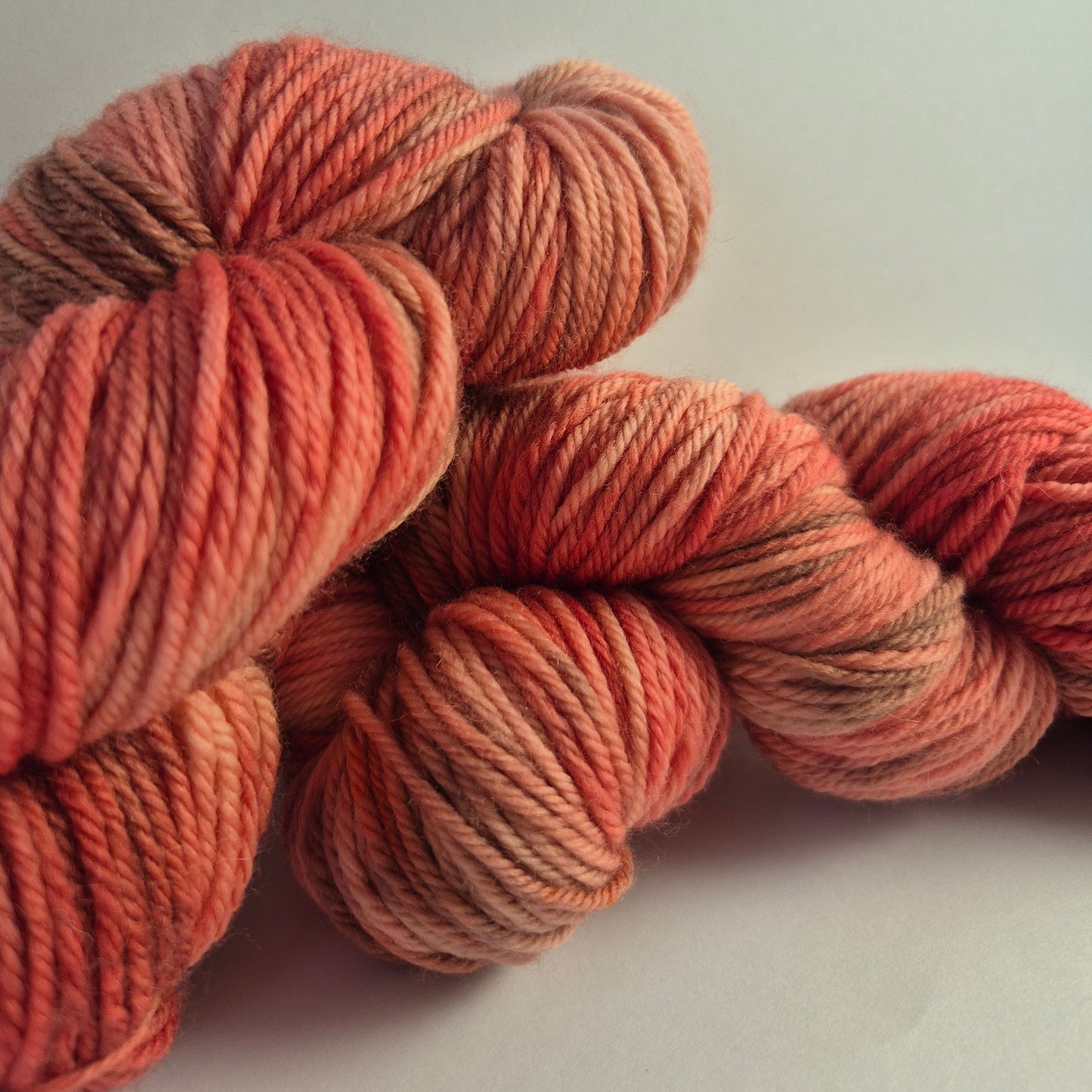 Skeins of red and brown hand-dyed DK yarn made from Australian Merino wool.