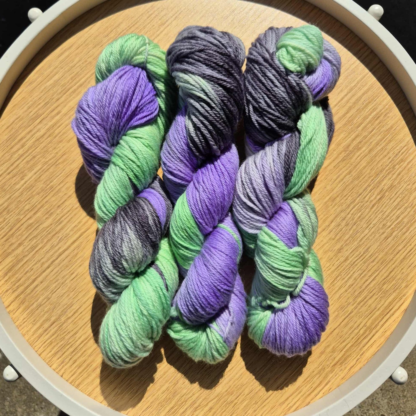 Green, black and purple skeins of yarn