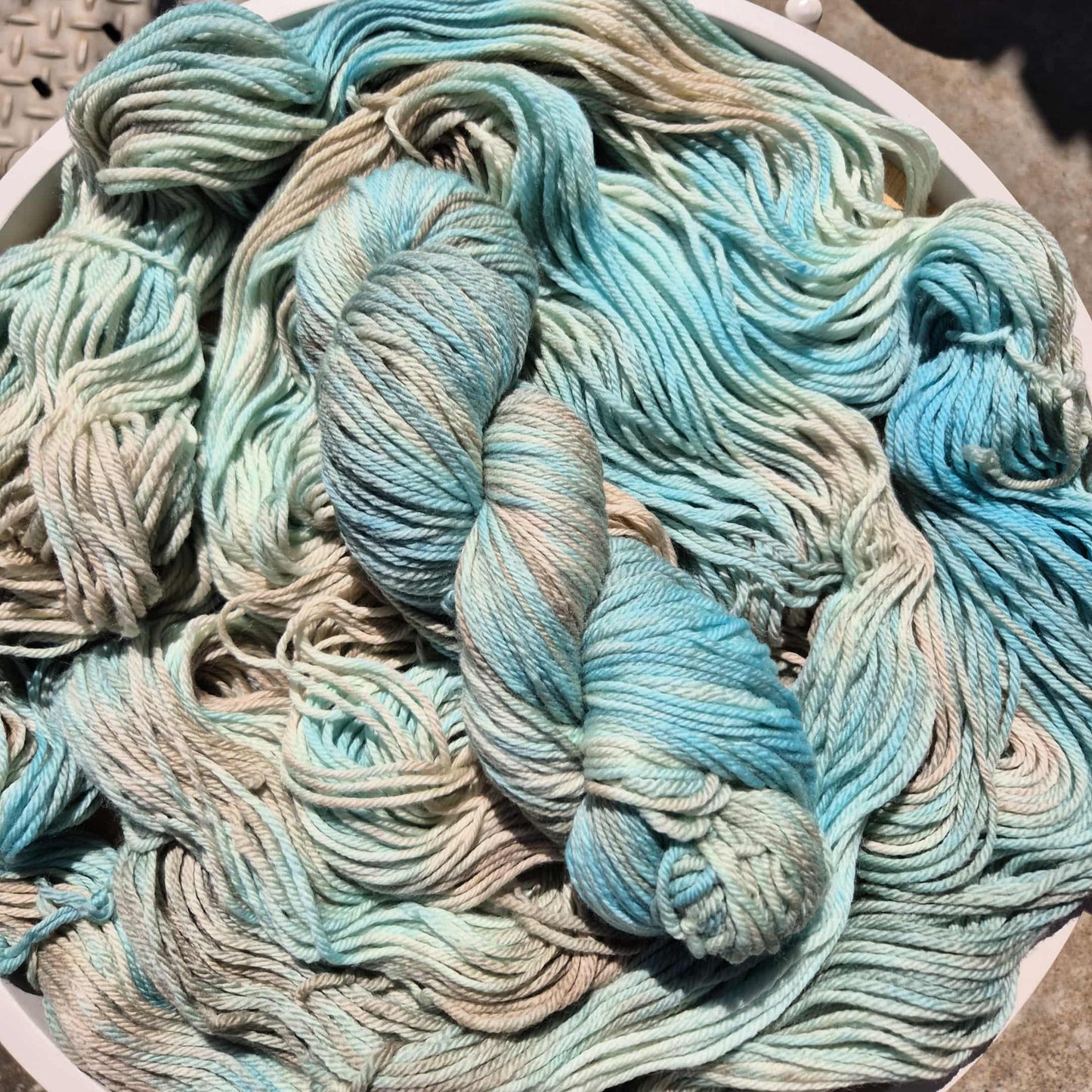 Table filled with skeins of blue and brown yarn on a textured surface