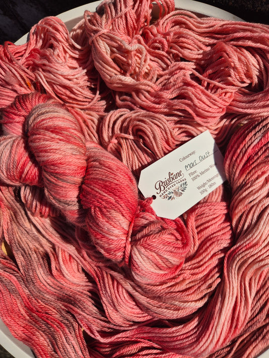 Red and brown skein of yarn with a label on a dark background
