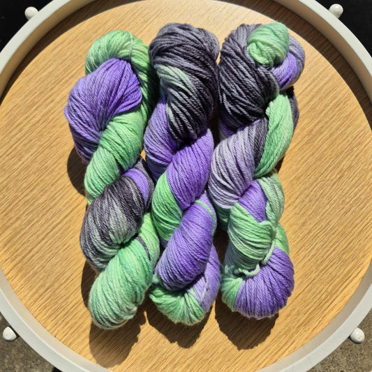 Green, black and purple skeins of yarn