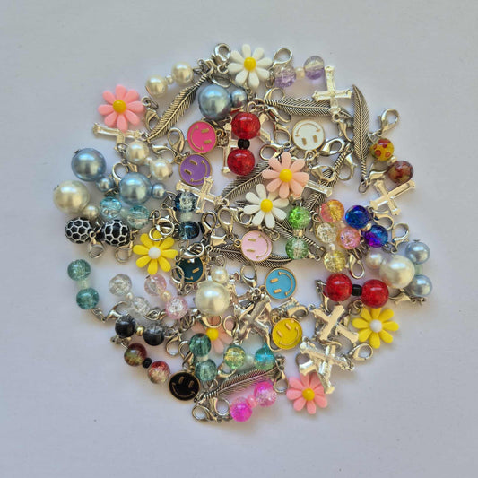 Collection of colourful stitch markers charms on a light background