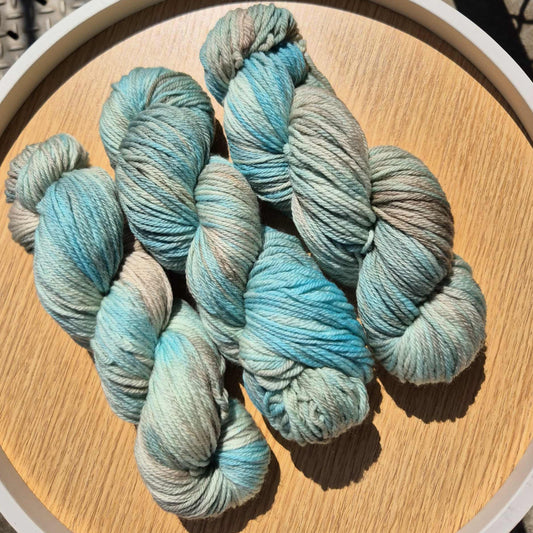 Blue and brown yarn skeins on a wooden surface